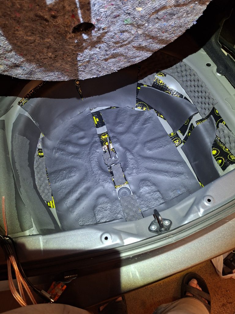 Toyota Corolla spare wheel well with foam insulation before adding extra pad
